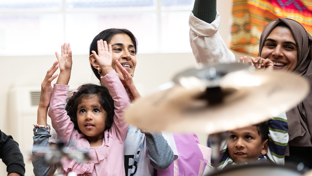 children and their mothers attend a music session